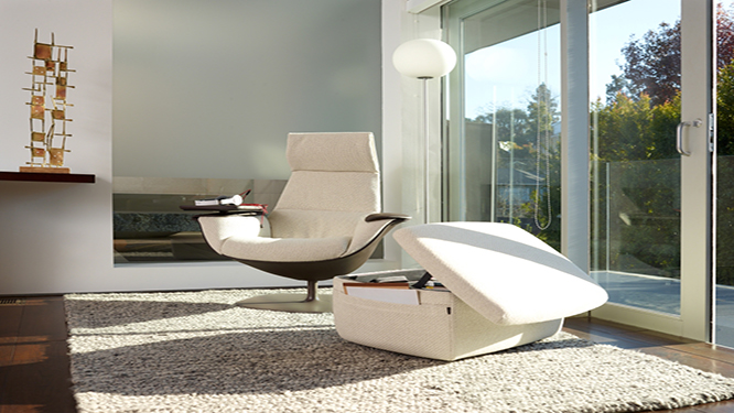 White lounge seating with matching ottoman with storage space inside, on cream colored rug in relaxation room.