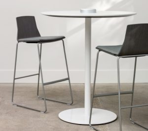 Two grey cafe-height chairs around tall round lounge table in grey room