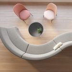 Overhead view of office social space with curved sectional sofa and pastel colored side chairs