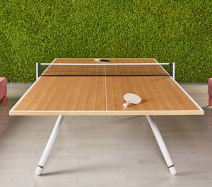 Custom Potrero415 wooden ping pong table inside office lounge area in front of green moss wall
