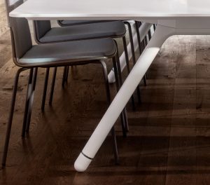 Dark wooden floor of office meeting room with white meeting table and grey meeting chairs