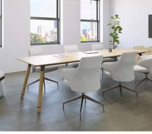 Long wooden conference table with white conference chairs, matching armrest, wooden storage credenza, and wall-mounted monitor