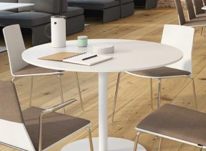 White laminate coffee table in office cafe space, with matching chairs and charging station
