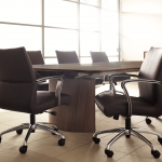 Leather conference chairs surrounding a wooden table in a meeting room.