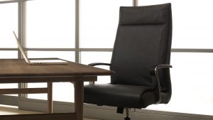 High back leather conference room chair at a wooden table