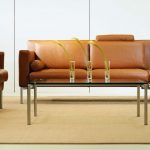Brown leather sofa with matching chairs and glass coffee table
