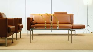 Brown leather sofa with matching chairs and glass coffee table