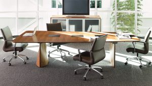 Office meeting space with plush leather chairs, grey carpeting, and long wooden conference room table