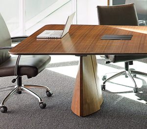 Office meeting space with plush leather chairs, grey carpeting, and long wooden conference room table