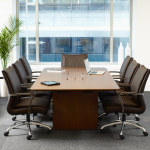 Meeting room overlooking view of opposite building with wooden table and matching leather conference chairs
