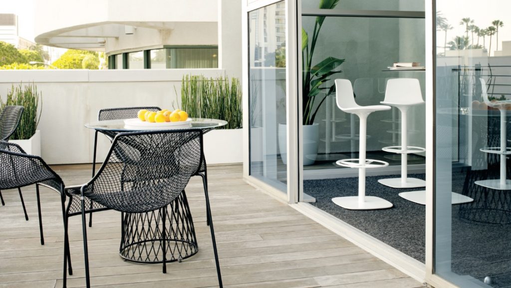 Indoor and outdoor office social spaces with cafe height stools and metal outdoor furniture