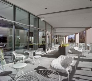 Outdoor office lounge space with metal outdoor furniture and matching tables