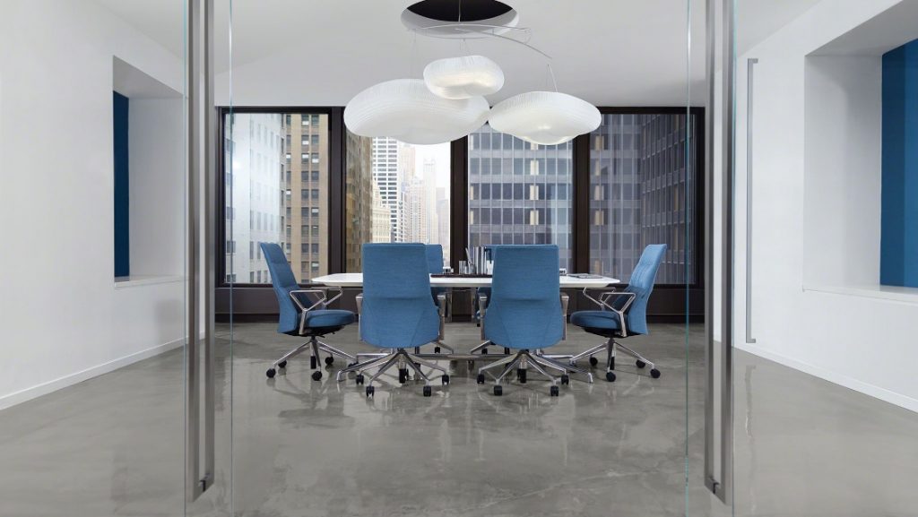 Modern office meeting room with blue high-backed conference chairs, white meeting table, and suspended lamps near a view of the city skyline