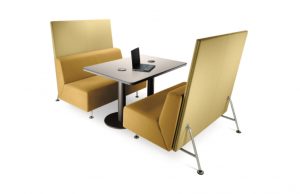 Yellow office couches with matching privacy screens around a metal table with laptop