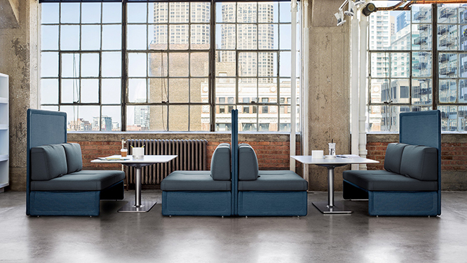 Cafe style booth seating with back dividers, large collaboration tables and windows looking out over a city.