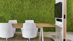 Indoor collaborative space with living moss wall, white chairs, and mobile whiteboard