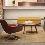Brown leather Bob office lounge chair, wood coffee table, and yellow upholstered bench on a rug
