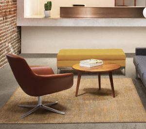 Brown leather Bob office lounge chair, wood coffee table, and yellow upholstered bench on a rug