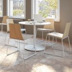Round dining tables and wooden chairs in office cafe space