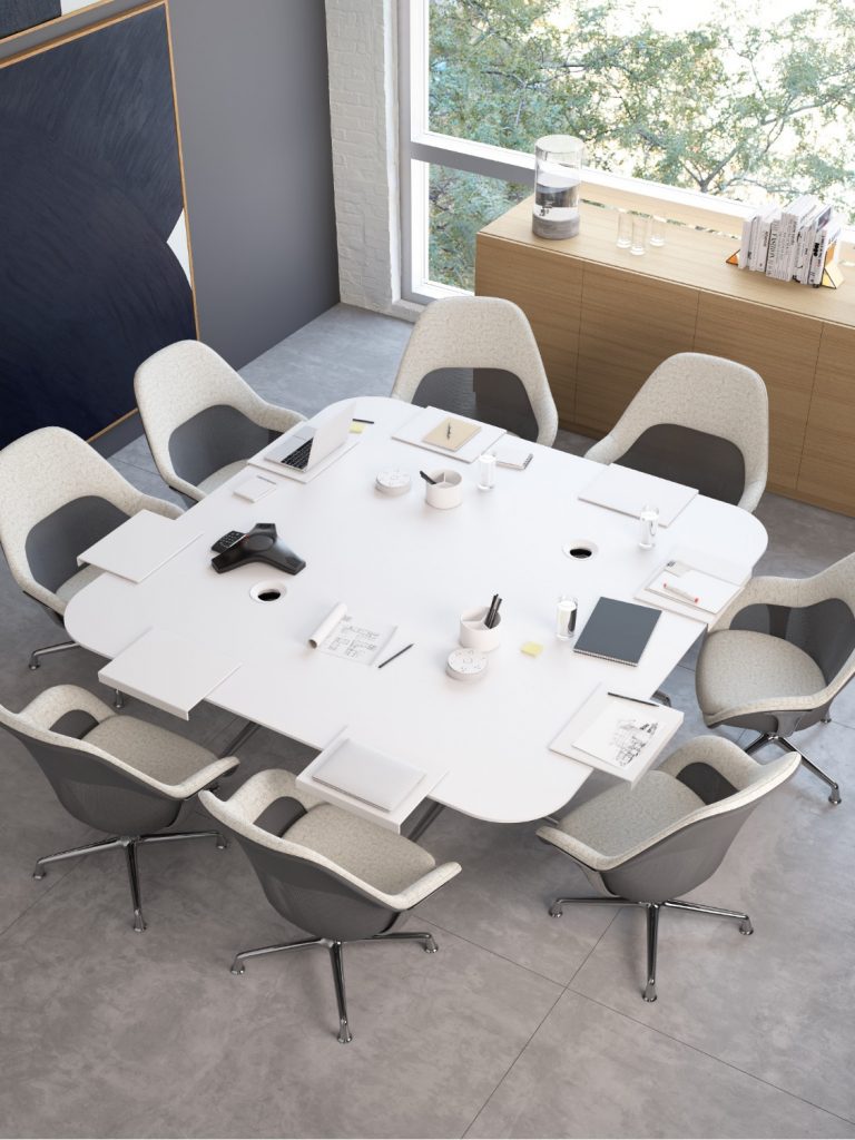 Creative collaborative space in office with white table, matching white chairs, wooden storage cabinet, and chalkboard on wall