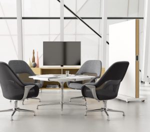 Grey fabric office chairs around round table with adjacent TV stand