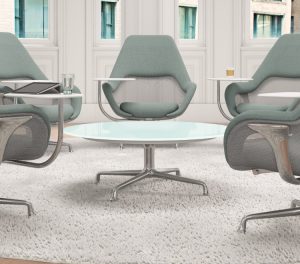 Office lounge space with green upholstered meeting chairs, round table in middle, and white outdoor rug