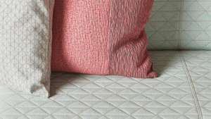 Detail of couch upholstery diamond-shaped stitching with throw pillows