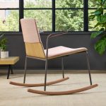 Soft pink upholstered rocking chair with metal frame and wooden rockers