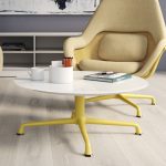 Lounge space in office with round coffee table, high backed arm chairs, and matching yellow bases on everything