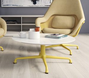 Lounge space in office with round coffee table, high backed arm chairs, and matching yellow bases on everything