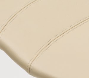 Detailed stitching on off-white leather stool seat