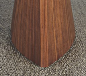 Pointed wooden base of office table on checked grey carpeting