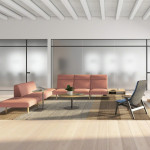 Office lounge area with bench seating, lounge chairs, monitor wall, and glass window walls