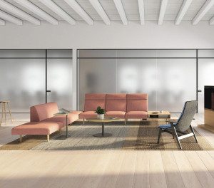 Office lounge area with bench seating, lounge chairs, monitor wall, and glass window walls