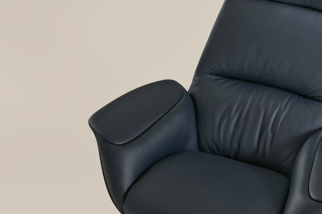 Close-up of black leather lounge chair with padded armrest and backrest