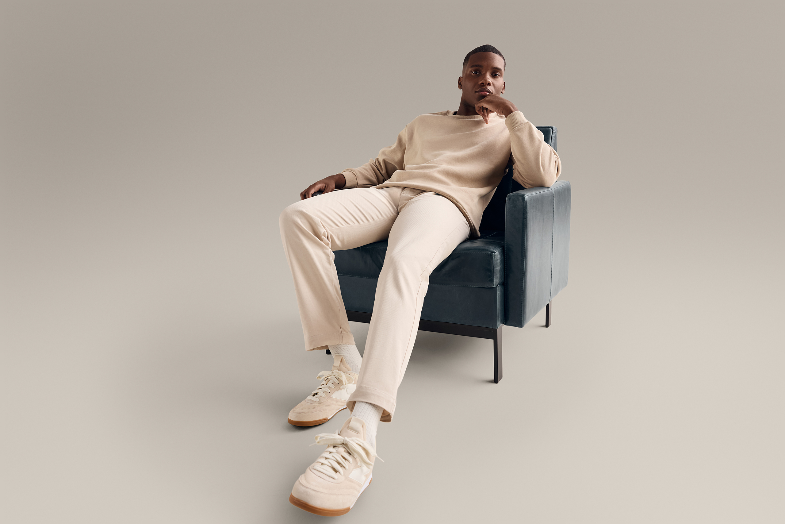 Man reclining with one hand on his head in a Millbrae contract lounge seating in emerald green