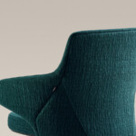 Side view of green upholstered lounge chair with textured fabric