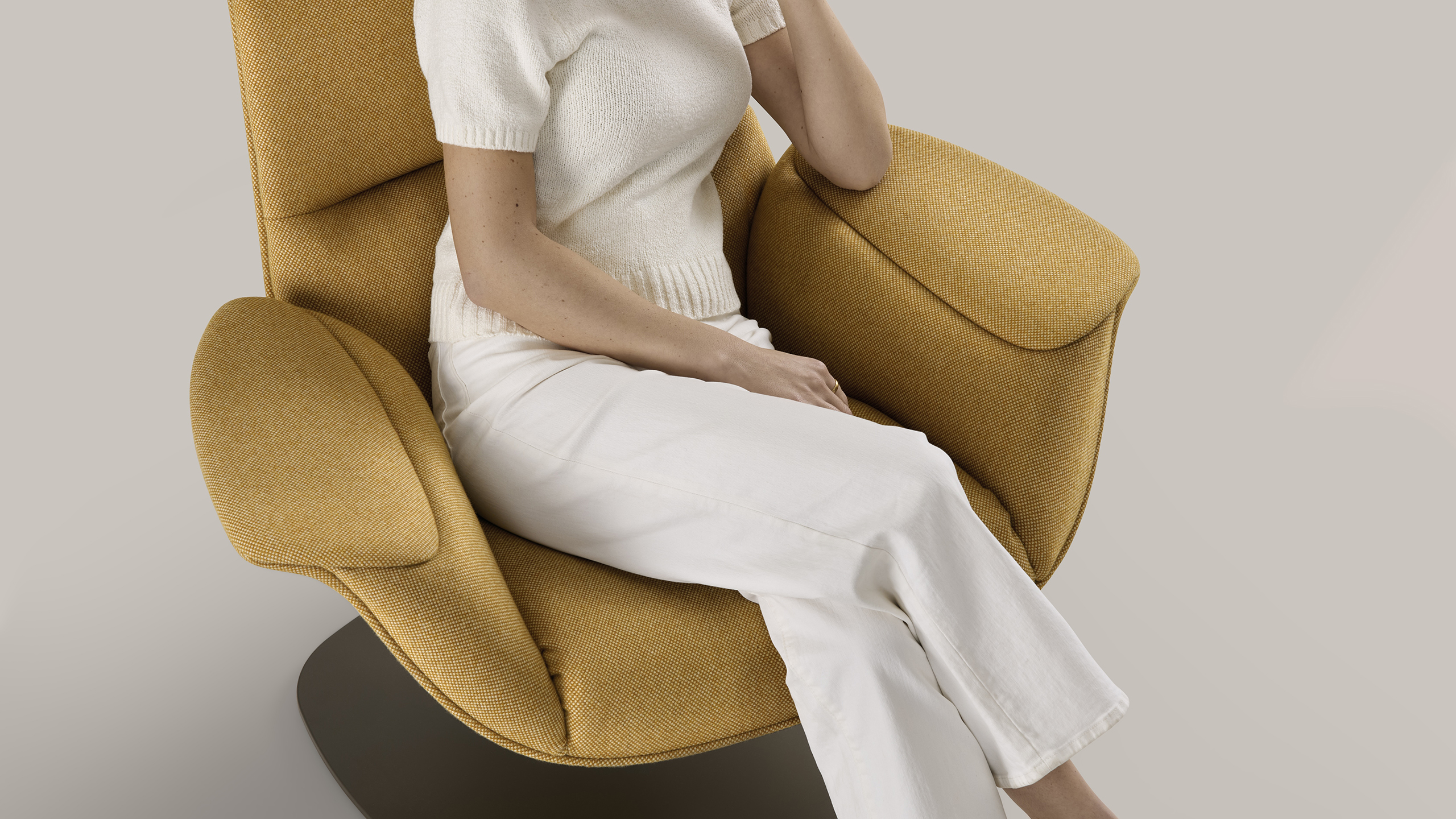 close up to a woman seated on a yellow massaud lounge seating