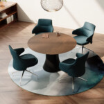 Modern meeting area with round wood table and four upholstered chairs
