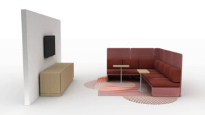 Modern lounge booth with red upholstered seating, side tables, wall-mounted screen, and storage cabinet