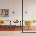 Large conference Table surrounded by four yellow chairs inside an office.