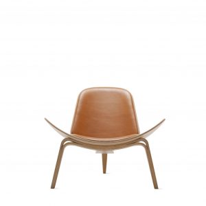 Shell lounge chair with modern curved base, light brown leather upholstery, and modern 3 leg base in light wood