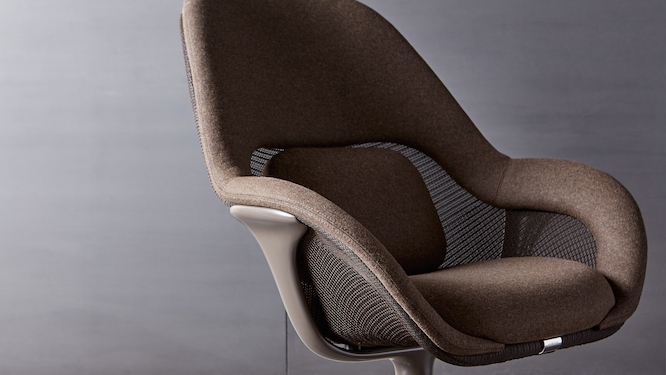 Brown finished lounge chair with grey background.