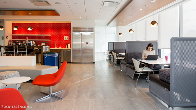 Kitchen area with red backsplash, red lounge chairs and dark grey booth style seating with light grey side chairs.