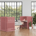 Two pink office privacy nooks around lounge chair and office desk with potted plants and glass window nearby