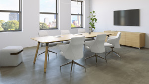 Long wooden conference table with white conference chairs, matching armrest, wooden storage credenza, and wall-mounted monitor