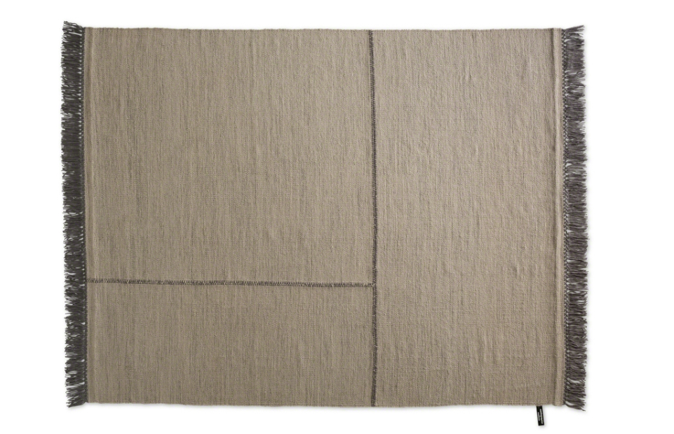 Tan area rug with dark lines in fabric and dark fringe around edges