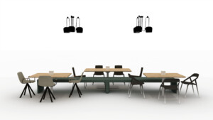 Collaborative workspace with connected wood tables, mixed seating, and pendant lighting