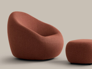 Orange upholstered lounge chair with matching ottoman on neutral background