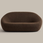 Brown upholstered lounge sofa with rounded shape on neutral background